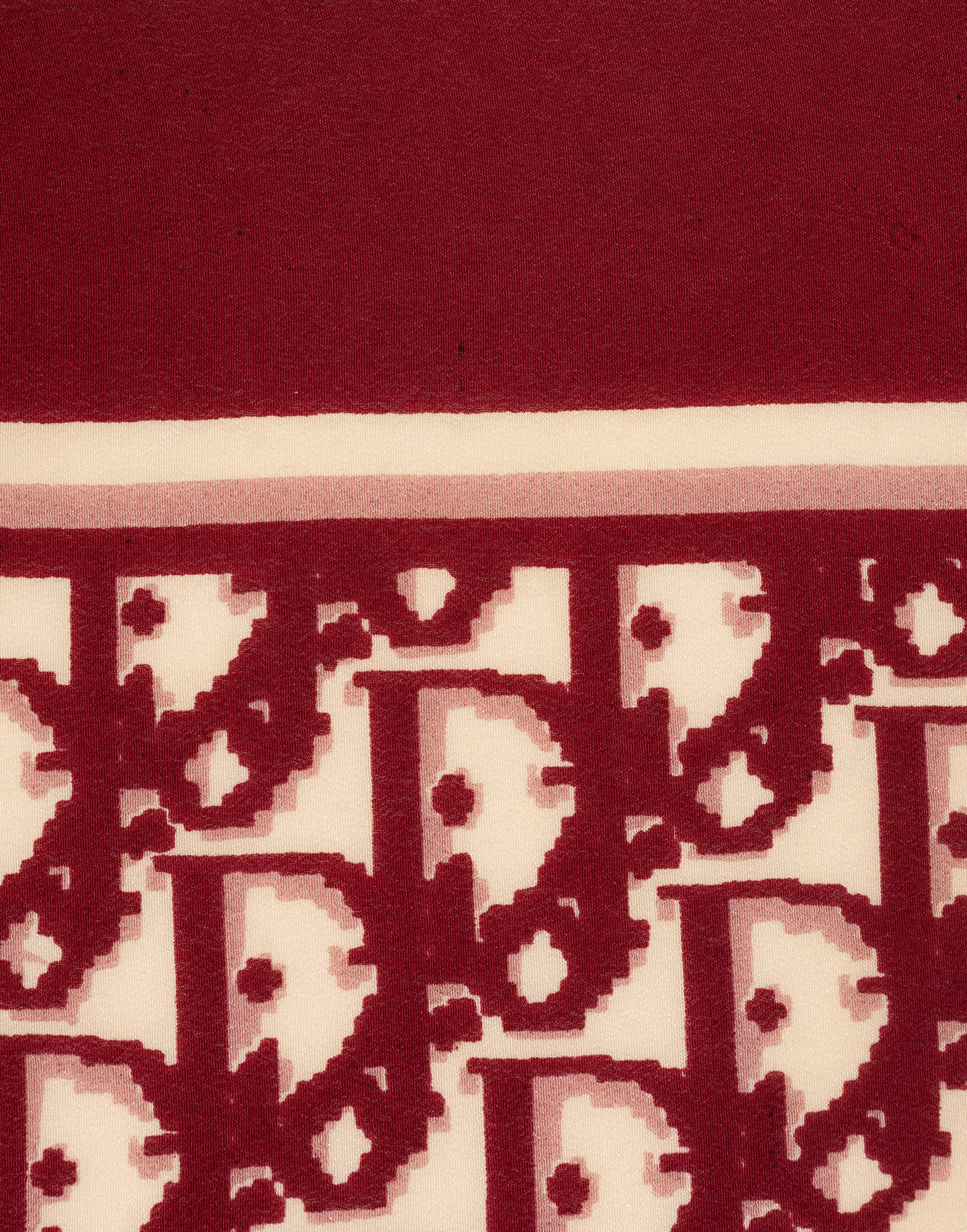 Red monogram scarf, photographed on a gray background.