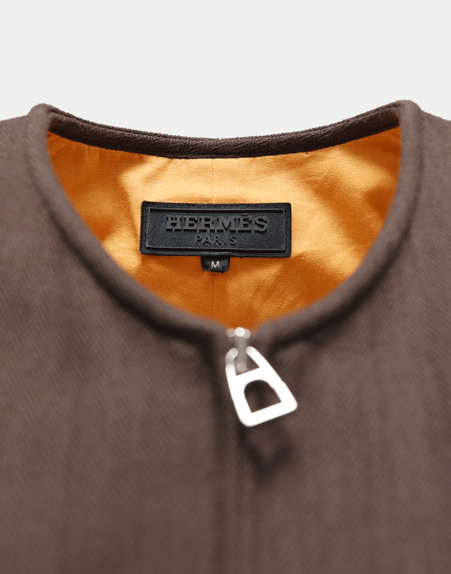 Gilet marrone con zip e due tasche, scattata su manichino ghost e sfondo grigio.