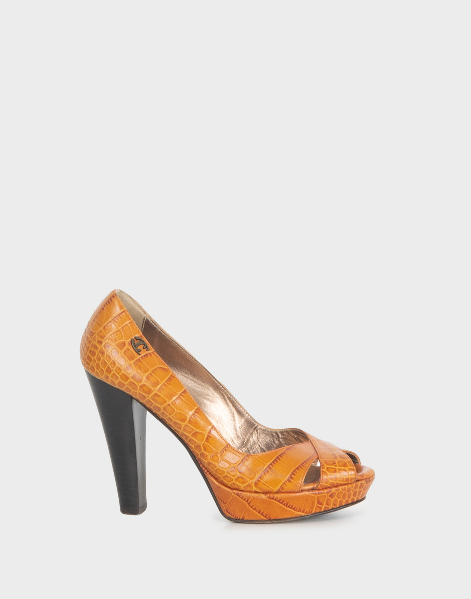 orange spiked heels in front, black heel and metal logo plaque applied