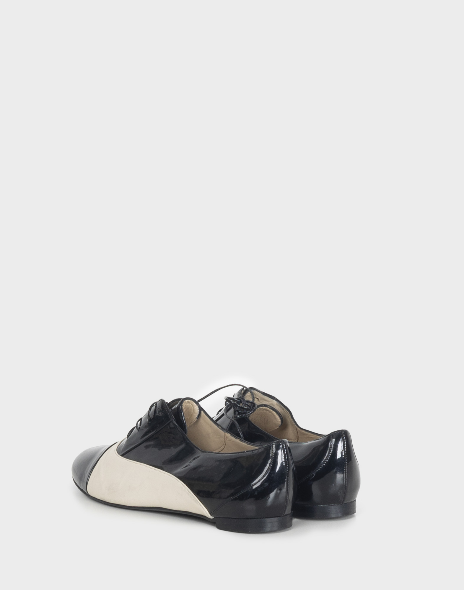 Women's black and white patent leather derby shoes with a round toe and laces.