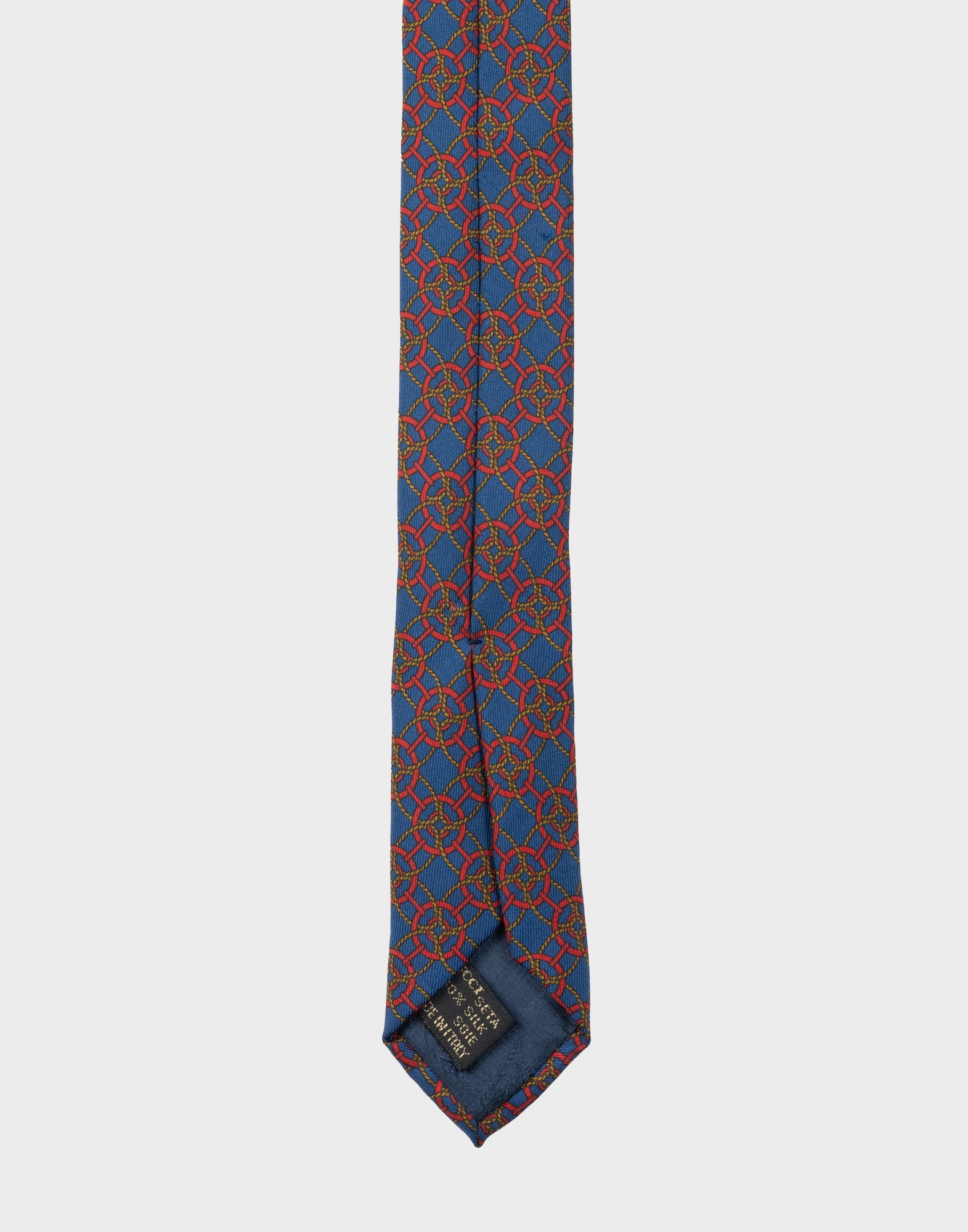 blue silk tie with red geometric pattern and gold-coloured braided cord