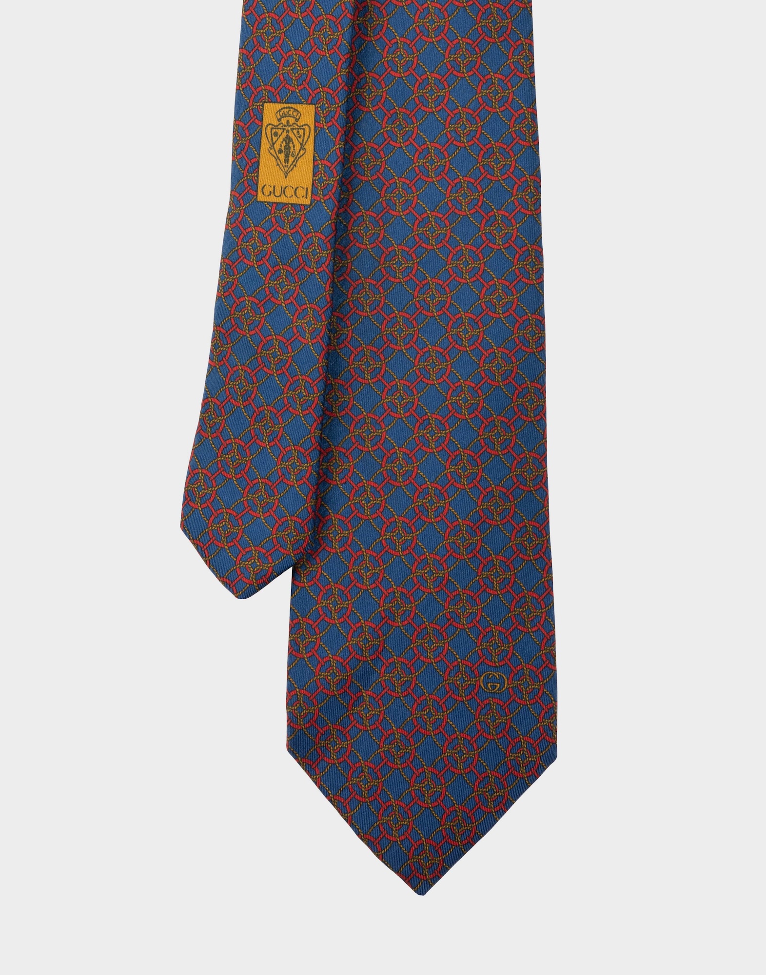 blue silk tie with red geometric pattern and gold-coloured braided cord