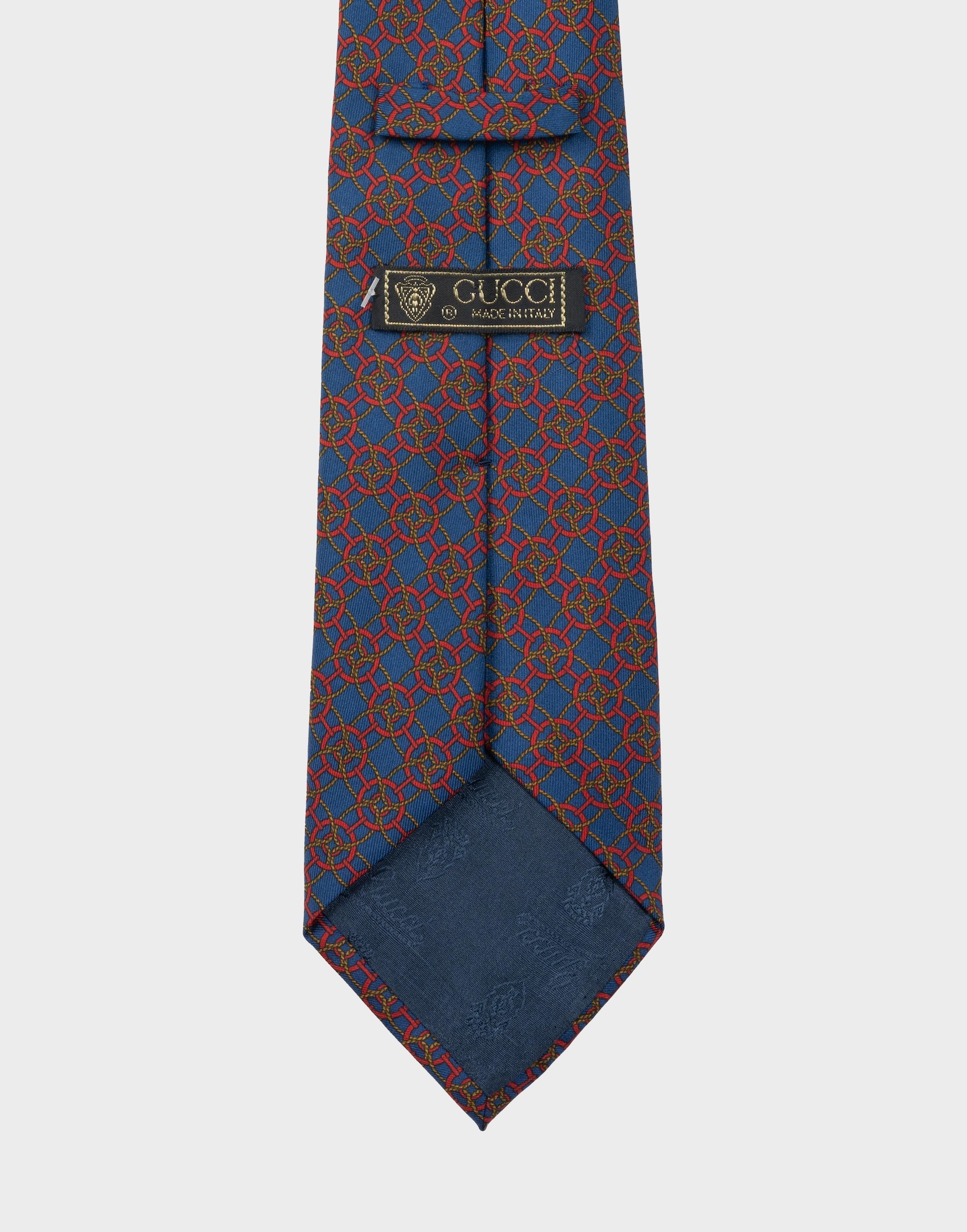 blue silk tie with red geometric pattern and gold-coloured braided cord