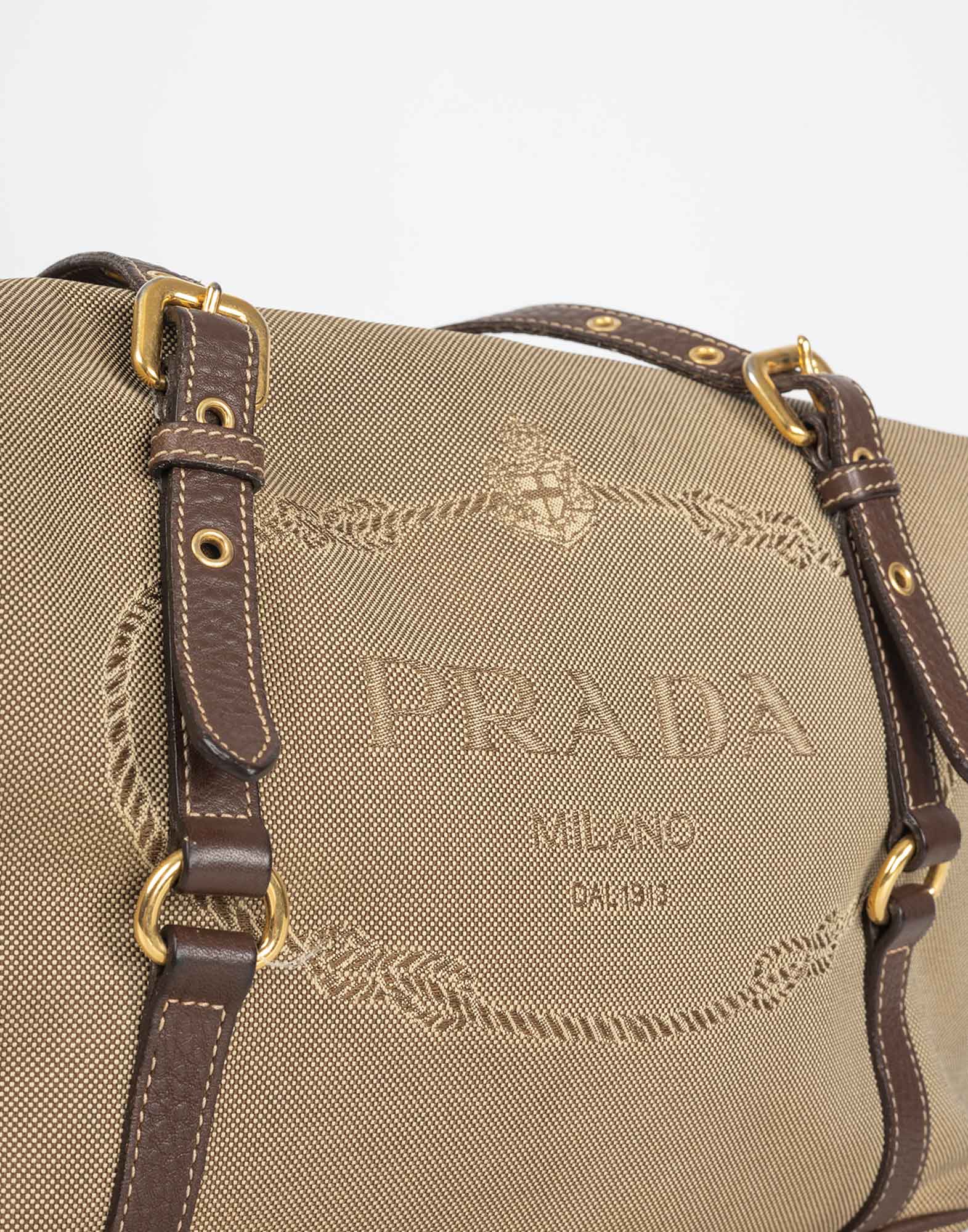 borsa beige in tessuto modello bauletto con logo ricamato sul davanti, doppio manico marrone in pelle con dettagli oro