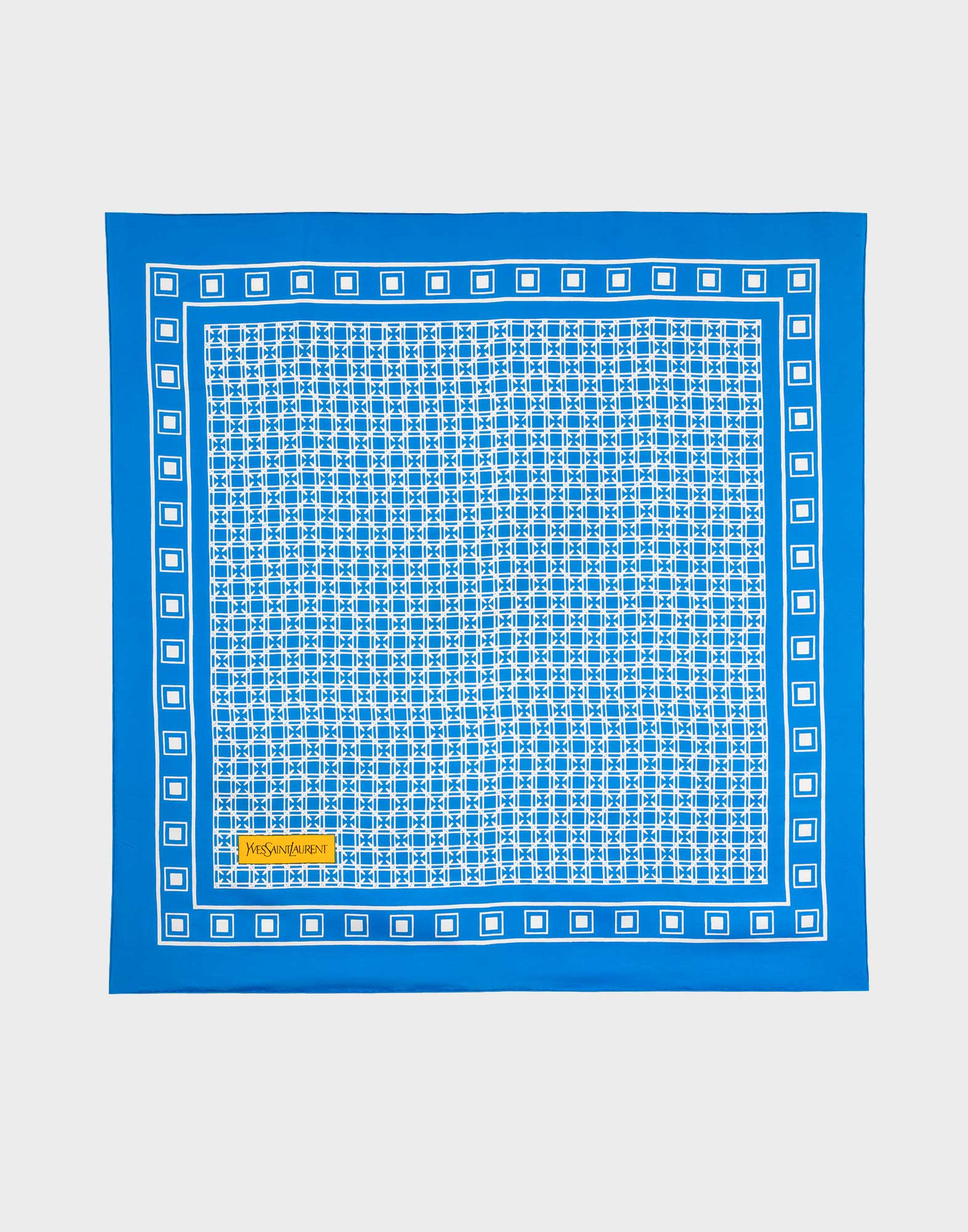 foulard quadrato celeste in seta con fantasia geometrica bianca e logo giallo yves saint laurent in basso a sinistra